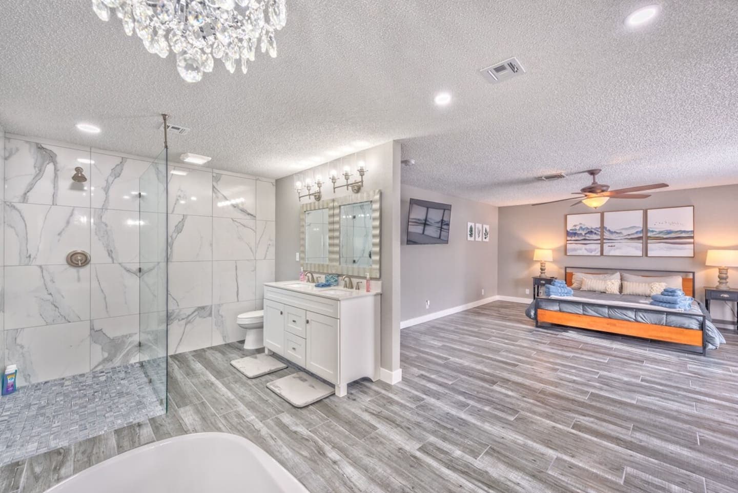Experience ultimate comfort in this spacious master suite. It features a plush King-sized bed, a Smart TV, and an open-concept spa-like bathroom. The ensuite boasts a large walk-in shower, dual vanity