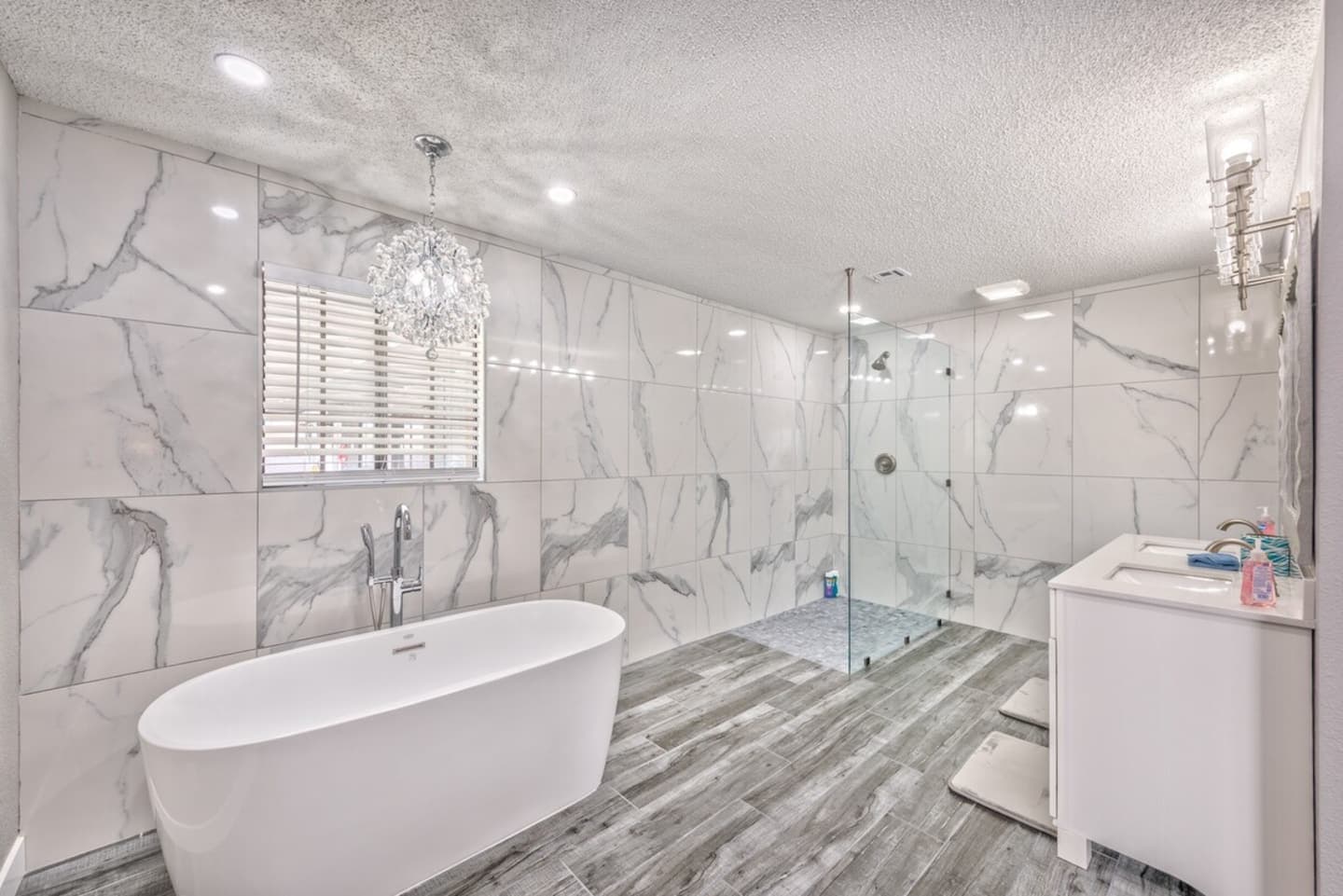  Indulge in luxury in this stunning master bath. It features elegant marble-effect tiling, a freestanding soaking tub, an expansive walk-in glass shower, and a modern dual vanity. A true private spa r